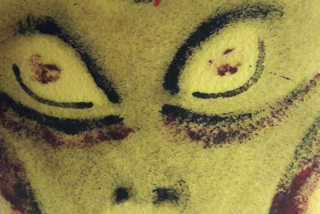 A face, yellow in colour with huge eyes